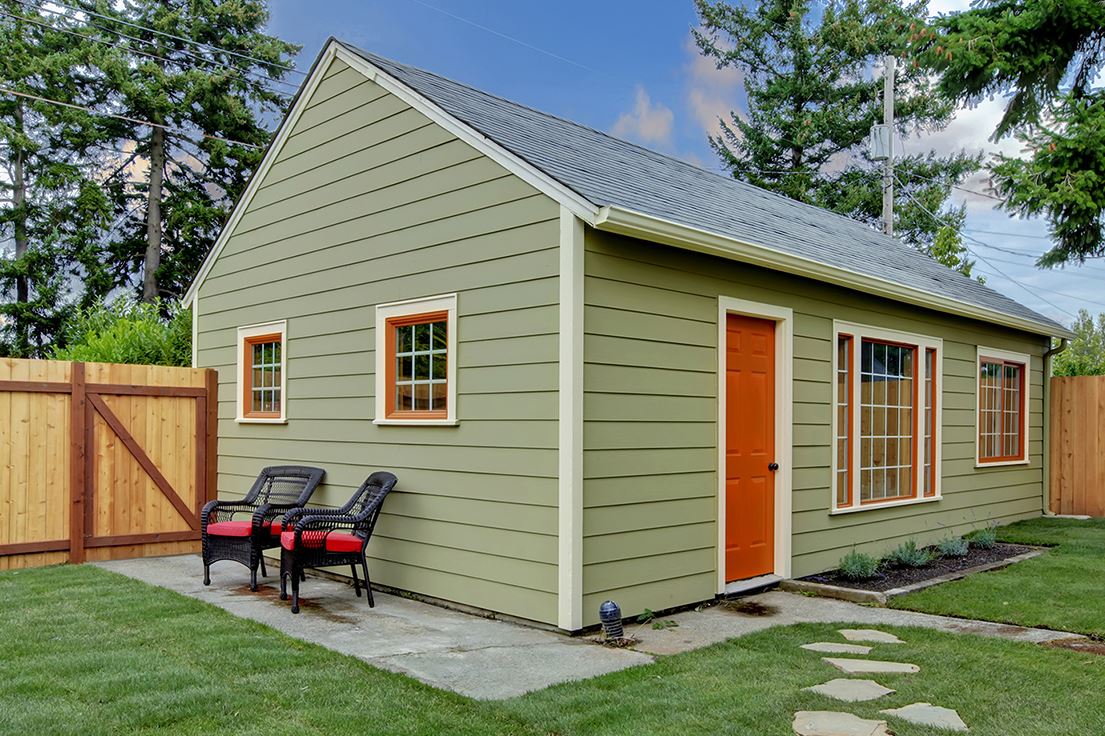 Light green detached ADU with a green lawn