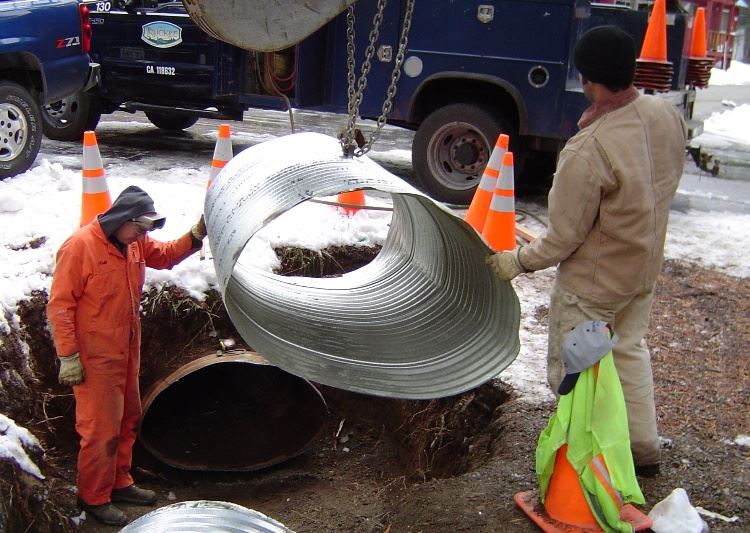 Workers Replacing a Drainage Pipe